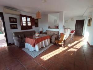 un soggiorno con tavolo e divano di Apartamento en Villa con Piscina a Málaga