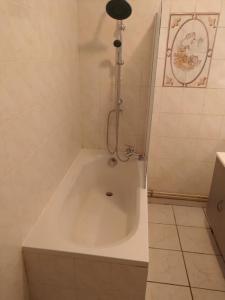 a white bath tub in a bathroom with a shower at Agréable maison 2 ch 5 mins Valenciennes et garage in Anzin