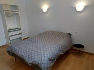 a bed in a bedroom with two lights on the wall at Agréable maison 2 ch 5 mins Valenciennes et garage in Anzin