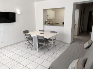 a kitchen with a table and chairs in a room at Agréable maison 2 ch 5 mins Valenciennes et garage in Anzin