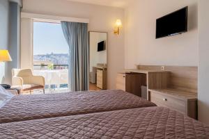 a hotel room with a bed and a large window at Oceanis Hotel in Kavála