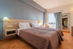 a bedroom with a large bed and a large window at Oceanis Hotel in Kavála