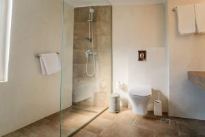 a bathroom with a glass shower with a toilet at Oceanis Hotel in Kavála
