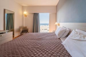 a hotel room with a large bed and a window at Oceanis Hotel in Kavála