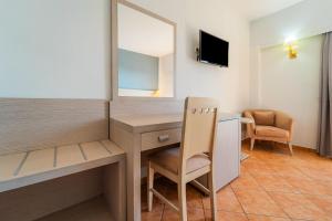 a room with a desk and a mirror and a chair at Oceanis Hotel in Kavála