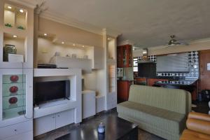 604@Amanzi 2-bedroom holiday apartment by the sea في امانزيمتوتي: غرفة معيشة مع أريكة ومطبخ