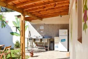 an outdoor kitchen with a grill and a refrigerator at Don Pototo Hospedaje Chapadmalal in Colonia Chapadmalal