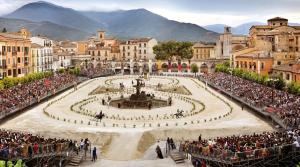 a crowd of people standing around a fountain in a city at La Castellina 23 in Sulmona