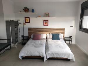 um quarto com uma cama grande e lençóis brancos em relax al pie de la alfaguara em Alfacar