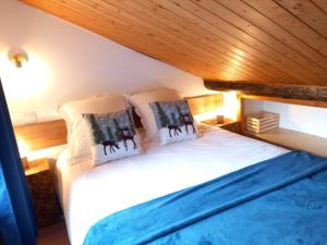 a bedroom with a bed with two pillows on it at Chalet de montagne au cœur de Doucy in Doucy