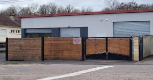 a building with two garage doors and a fence at Rien Que Nous 