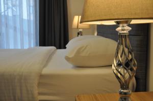 1 dormitorio con 1 cama con lámpara en una mesa en Dreams Inn Luxury Residences & Lifestyle, en Cimenli