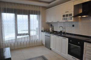 uma cozinha com armários brancos e uma grande janela em Dreams Inn Luxury Residences & Lifestyle em Cimenli