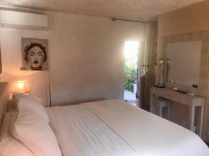 Mas Giro في Le Bar-sur-Loup: غرفة نوم بسرير ابيض ومرآة