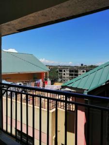 einen Balkon mit Blick auf ein Gebäude in der Unterkunft Entire serviced 2-bedroom apartment in Thindigua in Nairobi