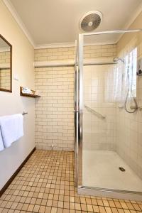 a shower with a glass door in a bathroom at Alfred Motor Inn in Ballarat