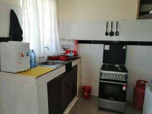 cocina pequeña con fregadero y fogones en Entire serviced 2-bedroom apartment in Thindigua, en Nairobi