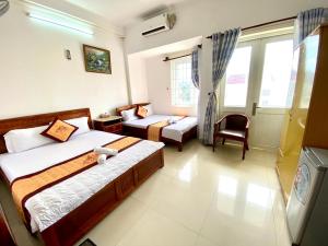 a bedroom with two beds and a couch and a chair at Ngoc dung MoTel in Vung Tau