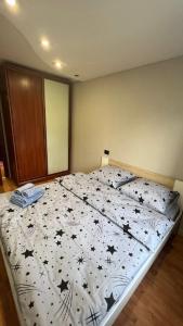 a bedroom with a bed with a black and white comforter at Obolonskiy Prospekt Apartments 16Є in Kyiv