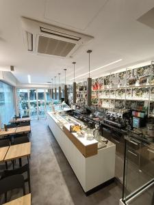 a restaurant with a long counter with tables and chairs at Residence Hotel Angeli in Rimini