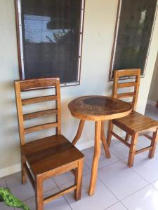 dwa krzesła i stół i stół i krzesło w obiekcie D's Oceanview Beach Resort w mieście Siquijor
