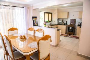 a kitchen with a wooden table and chairs in a room at Dylan Shawmutt Luxurious 3 Bedroom Apartment in Nakuru