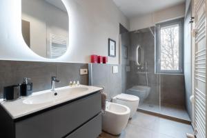 La salle de bains est pourvue d'un lavabo, de toilettes et d'un miroir. dans l'établissement Incantevole Appartamento in centro ad Alba, à Alba