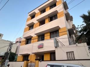 a tall yellow and white building at M K Raja Hotel in Kelambākkam