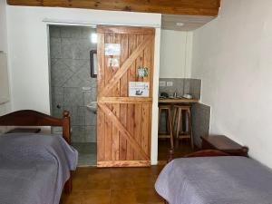 a bathroom with a sliding door with a shower and two beds at Don Pototo Hospedaje Chapadmalal in Colonia Chapadmalal