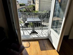 an open door to a balcony with a table on it at Appartement Sabatier T4 avec terrasse et jardin in Carcassonne