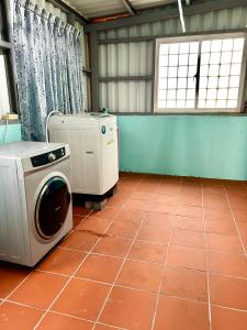 a room with a washing machine and a tiled floor at 澎湖菊舍民宿一館 in Magong