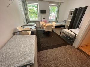 um quarto com duas camas e uma mesa e cadeiras em Bigus em Berlim