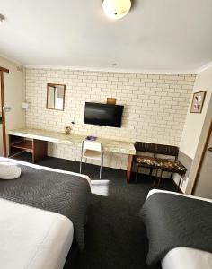 a hotel room with two beds and a flat screen tv at Alfred Motor Inn in Ballarat
