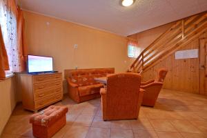 a living room with a table and chairs and a television at Ośrodek Wypoczynkowy Puszczyk Domek Akacjowy- Apartament -Willa in Sieraków +15 photos
