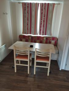 a table and two chairs in a room with a couch at CAMPING L’ELYSÉE *** in Le Grau-du-Roi