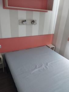 a bed in a room with a red and white wall at CAMPING L’ELYSÉE *** in Le Grau-du-Roi