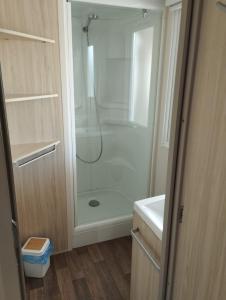 a shower with a glass door in a bathroom at CAMPING L’ELYSÉE *** in Le Grau-du-Roi