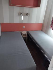 a small room with two beds in it at CAMPING L’ELYSÉE *** in Le Grau-du-Roi