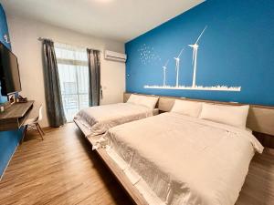 馬公市的住宿－澎湖菊舍民宿一館，卧室配有两张挂在墙上的风车床。
