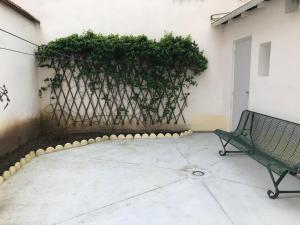 una panchina verde seduta di fronte a una recinzione di LE MOMBRUN - Parking Privé - Hypercentre - Patio Intérieur a Vichy