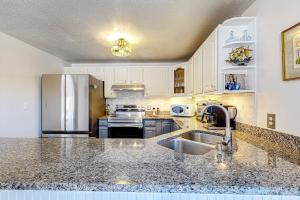 a kitchen with white cabinets and a stainless steel refrigerator at Serenity Now & Ever in Owls Head