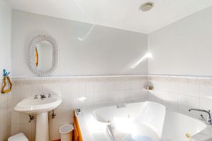 een witte badkamer met een bad en een wastafel bij Serenity Now & Ever in Owls Head