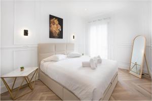 Un dormitorio blanco con una cama y un espejo. en Hypercentre - 4 mn Monaco - Luxueux - BR, en Beausoleil