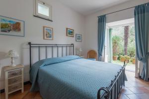 a bedroom with a bed with a blue comforter and a window at Agriturismo Villa Caterina in Levanto