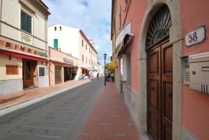 an empty street in an alley between buildings at Appartamento VIAROMA58 - Vicinissimo al mare con clima e posto auto in Marina di Campo
