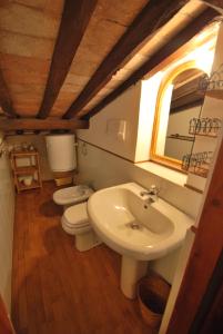 a bathroom with a sink and a toilet and a mirror at Appartamento VIAROMA58 - Vicinissimo al mare con clima e posto auto in Marina di Campo +21 photos