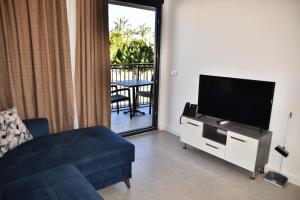 sala de estar con TV y sofá en STELLA APART-SUIT HOTEL -All Inclusive-, en Antalya