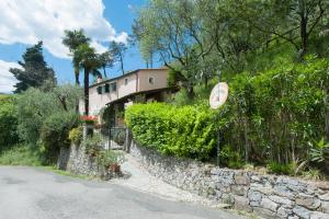 a house on the side of a stone wall at Agriturismo Villa Caterina in Levanto