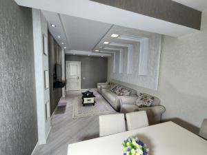 a living room with a couch and a table at Park Azure Best apartment in Baku