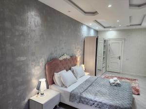 a bedroom with a large bed and a wall at Park Azure Best apartment in Baku